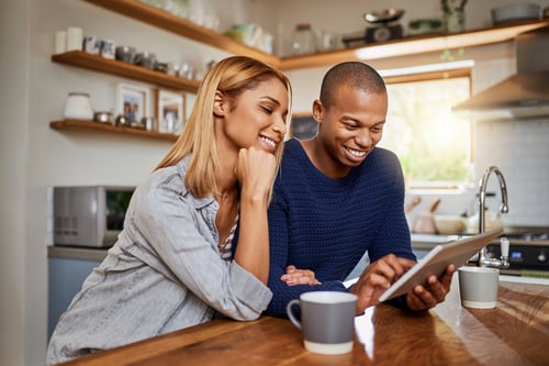 Couple in kitchen with ipad, GettyImages-1011271228