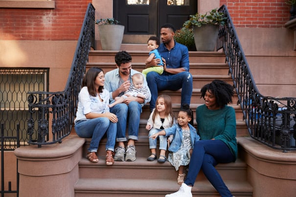 family hanging out with neighbors on a city porch