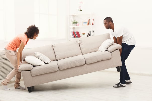 couple moving furniture in home