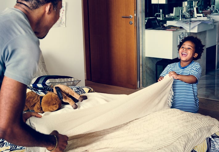 Dad and son making the bed