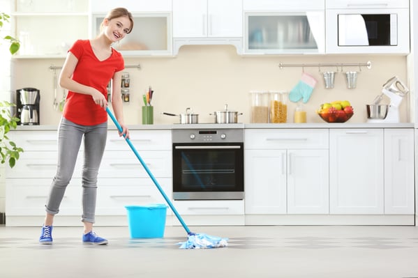 Happy woman mopping the kitchen floor