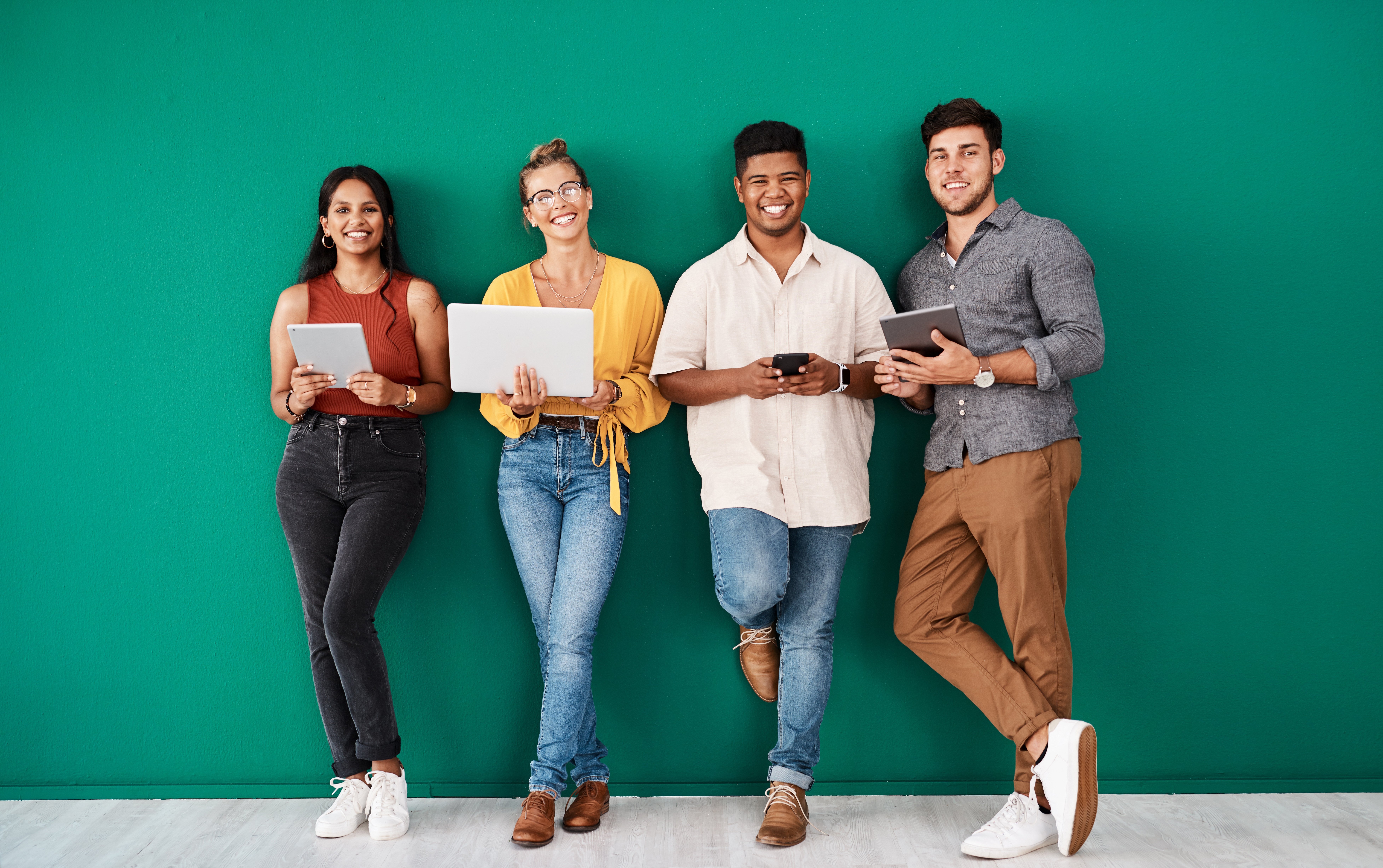 Four people leaning against a wall. 