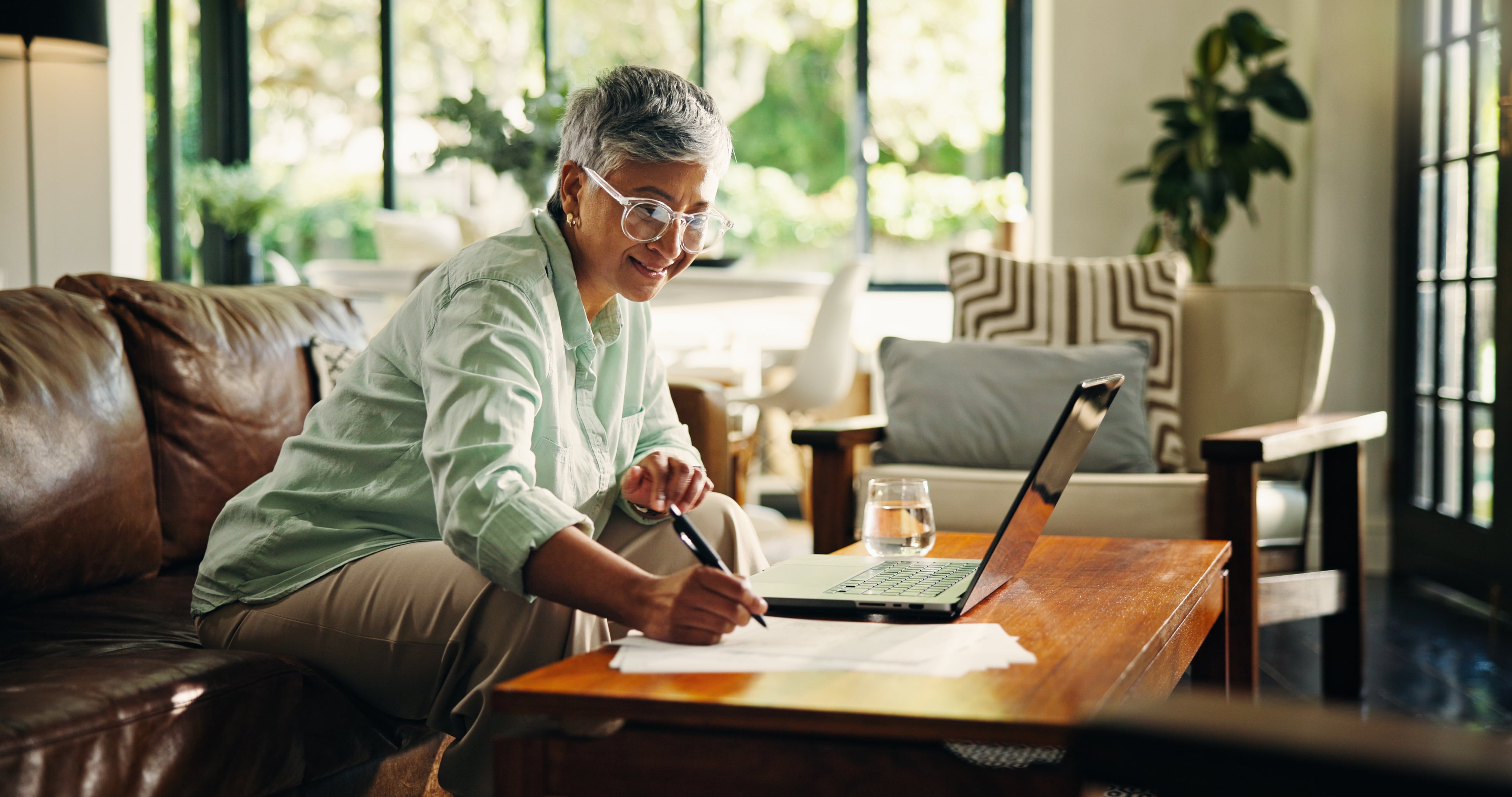 A woman on her computer taking notes. 