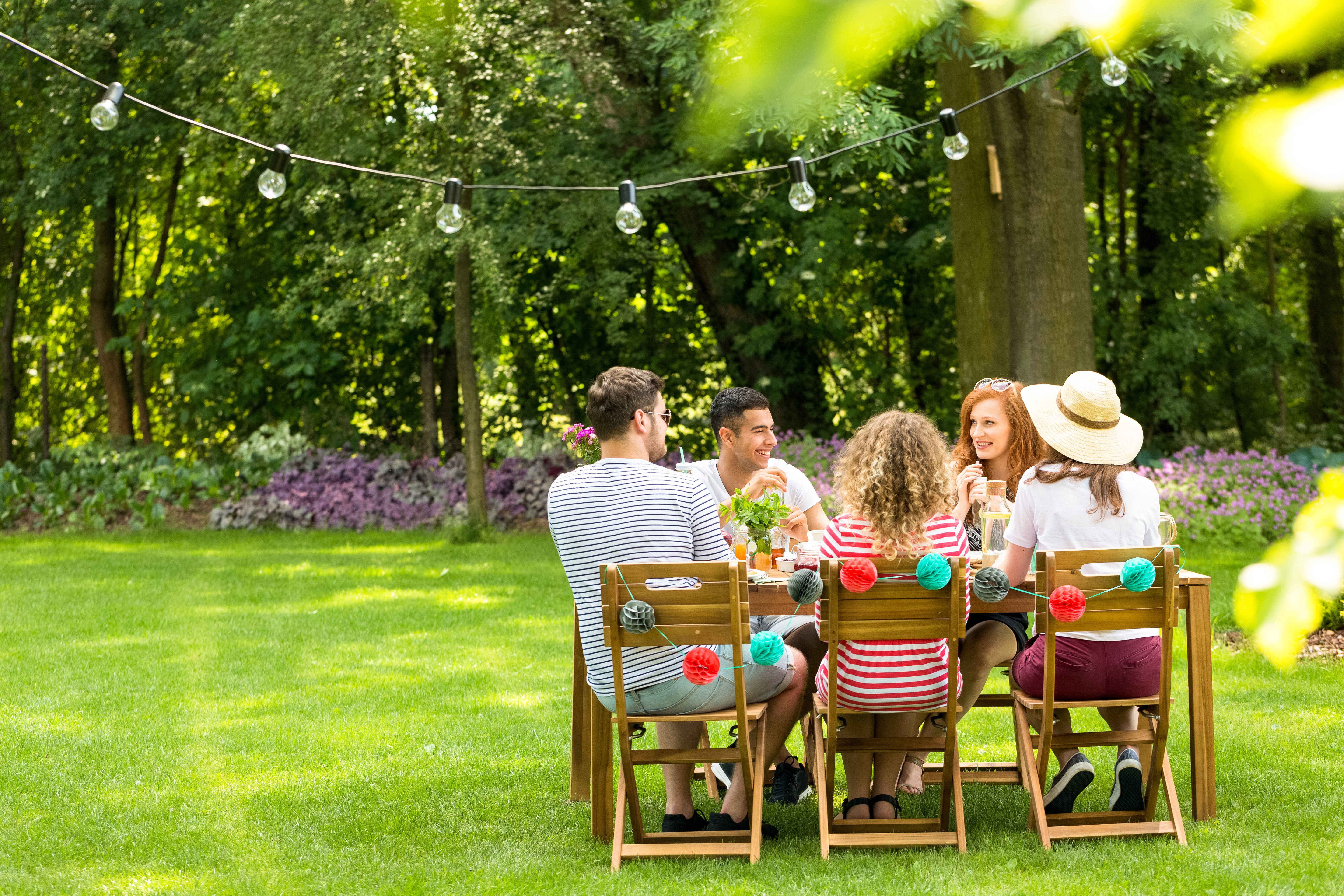 Group of friends enjoying a get-together in spring. They are smiling and having conversation.