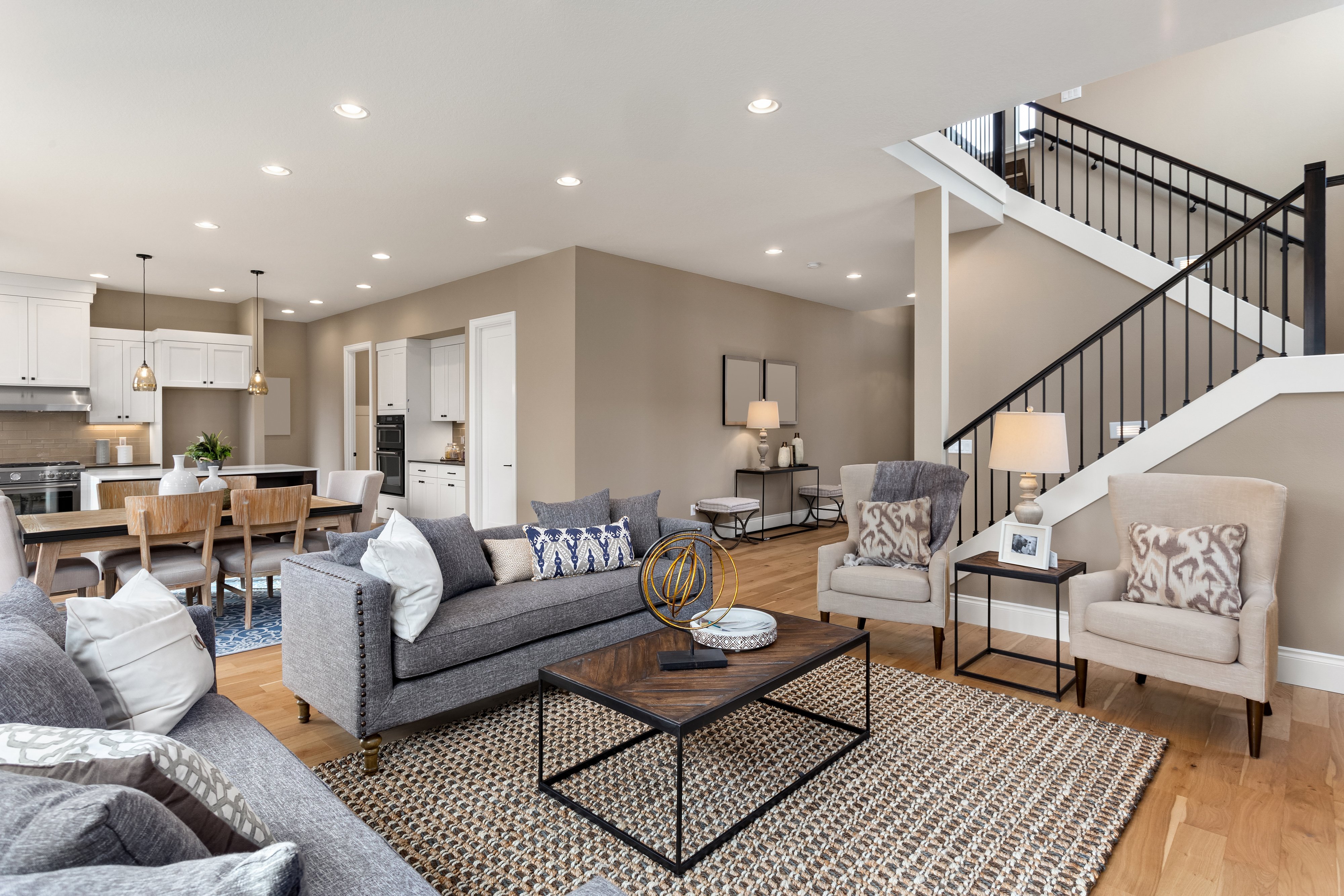 Home with an open floorplan, showing living room in the foreground and kitchen in the background.