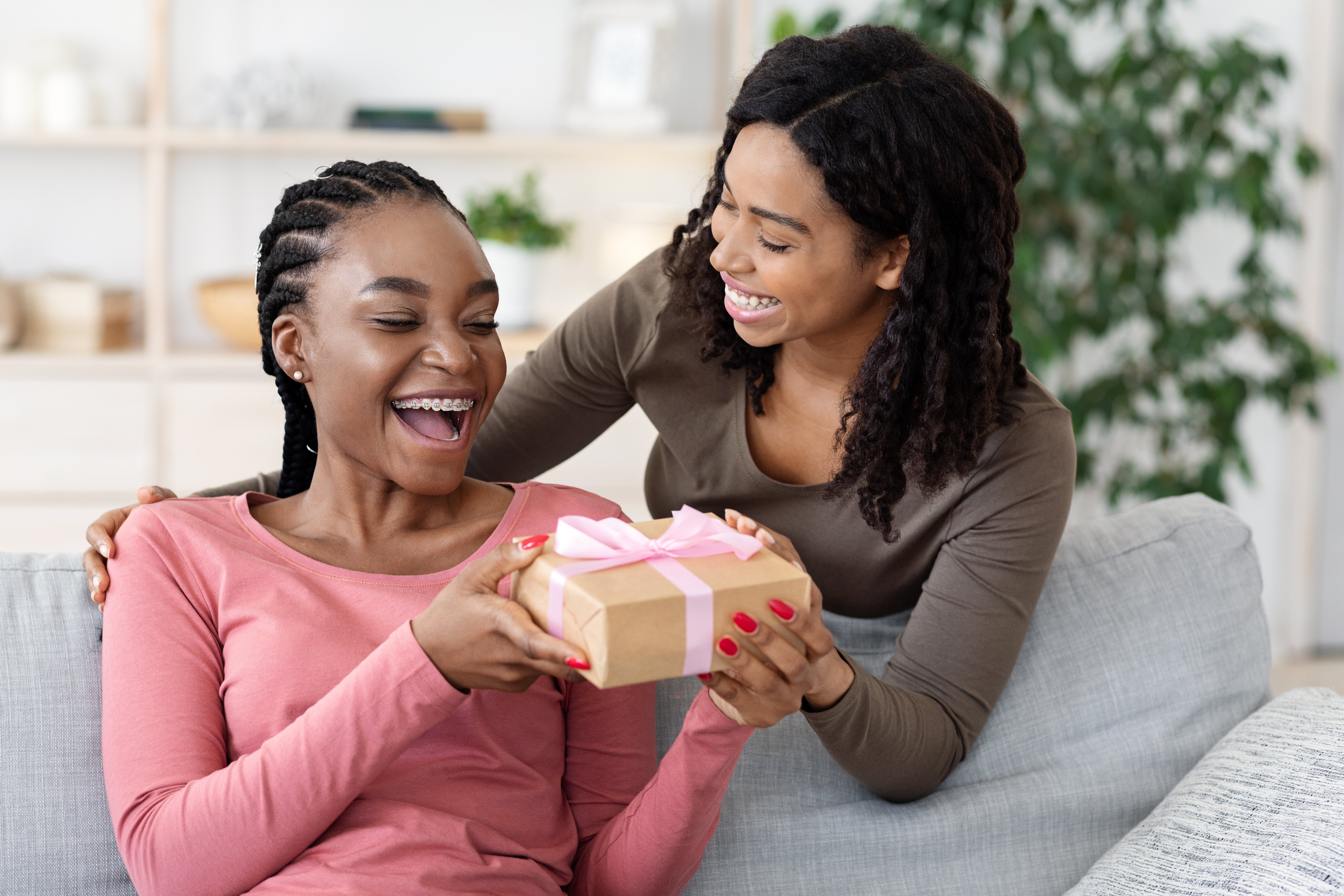 Woman giving a gift to a friend at home