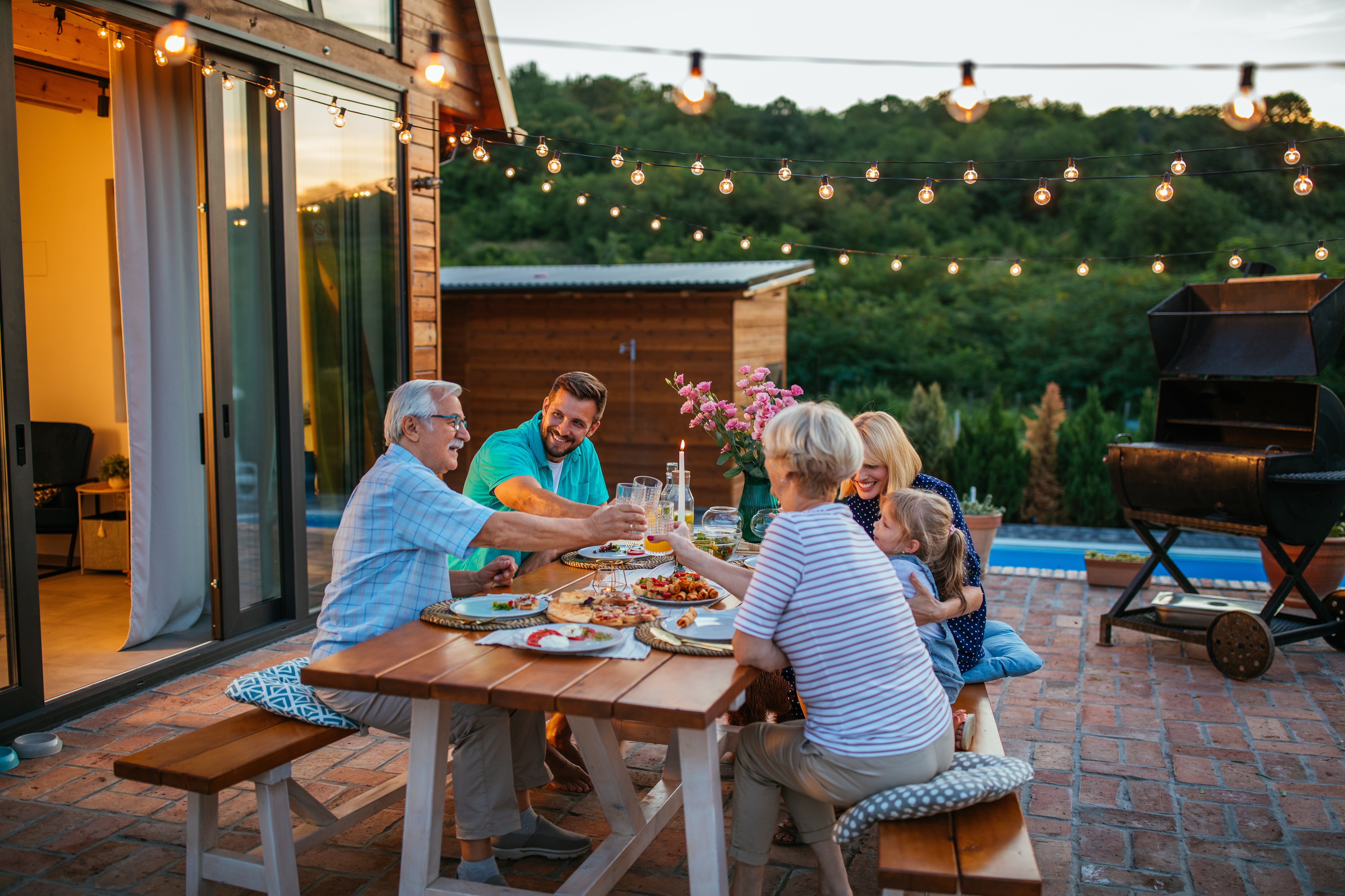 Three generations of family during dinner, celebrating holiday together in the backyard.